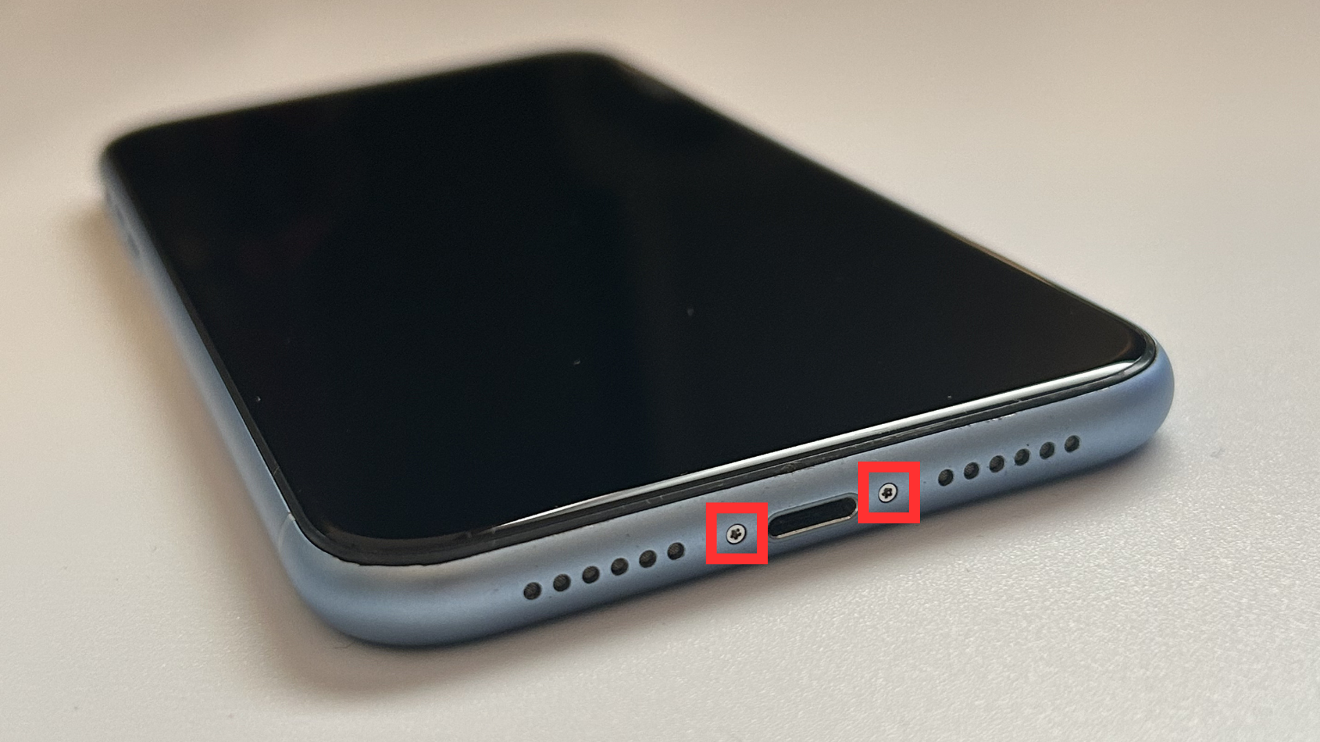 Close-up of screws on the bottom edge of the iPhone XR