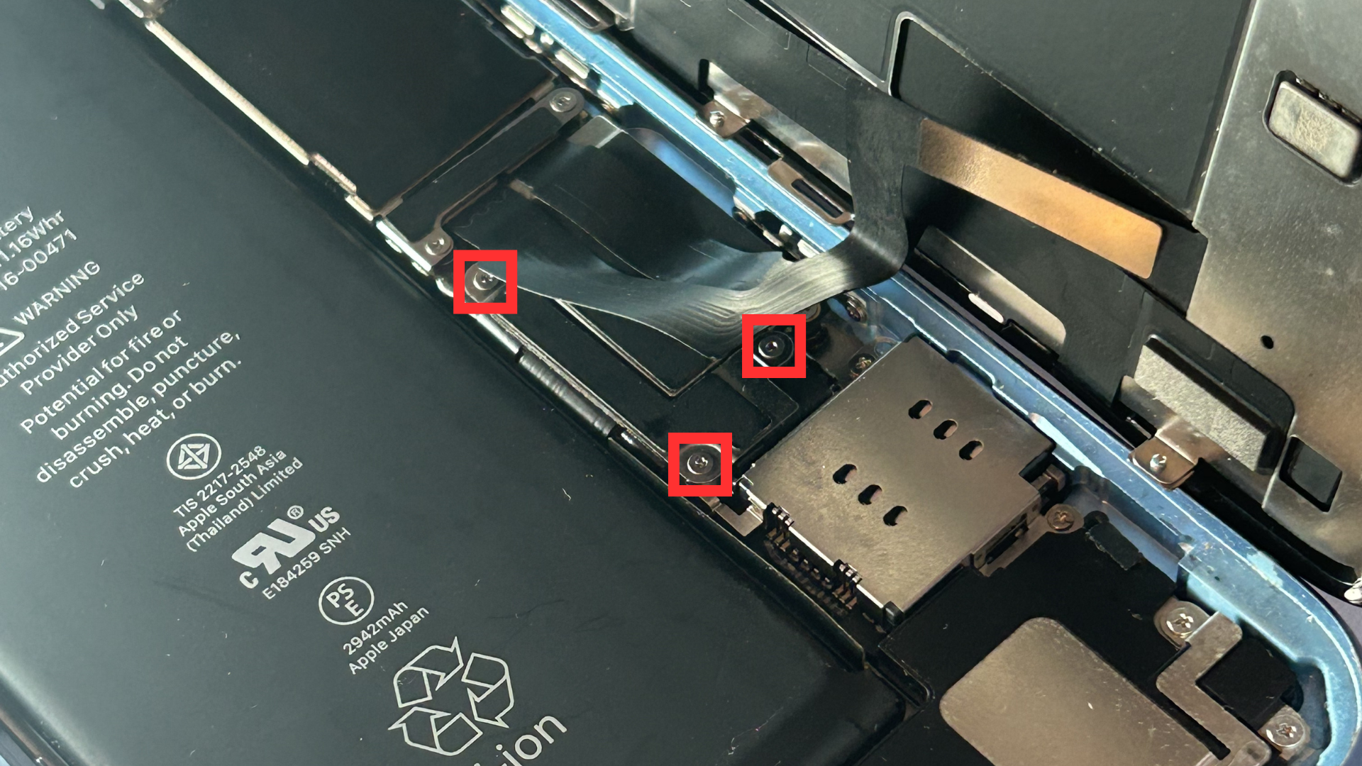 Close-up of the first metal shield and the three screws holding it in place