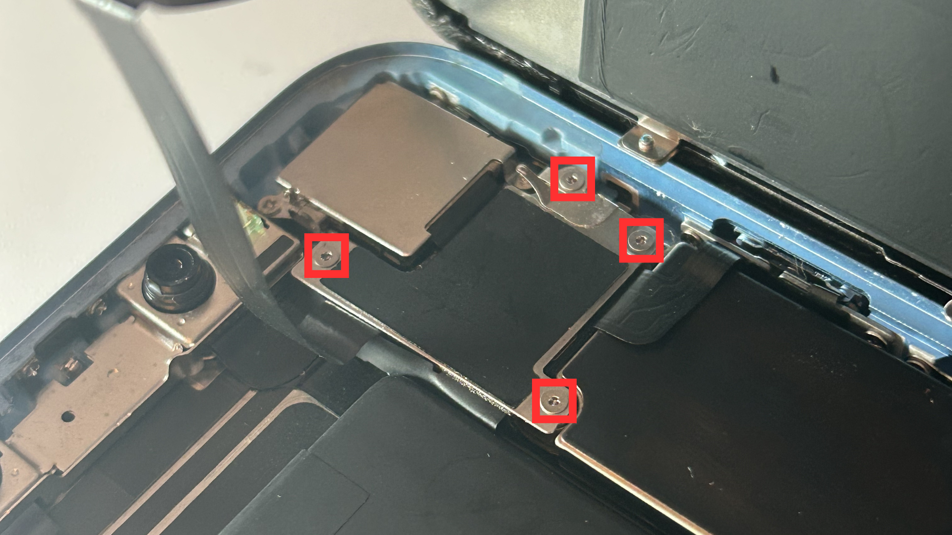 Close-up of the last metal shield and the four screws holding it in place