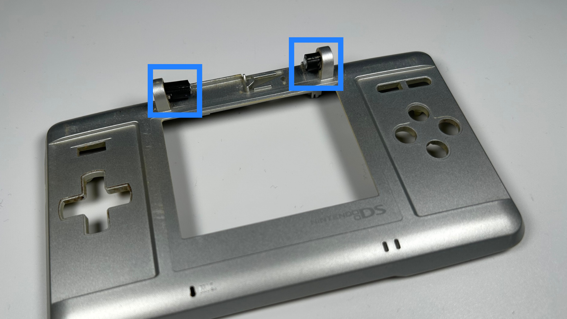 Two black Nintendo DS hinge pieces installed in their correct slots