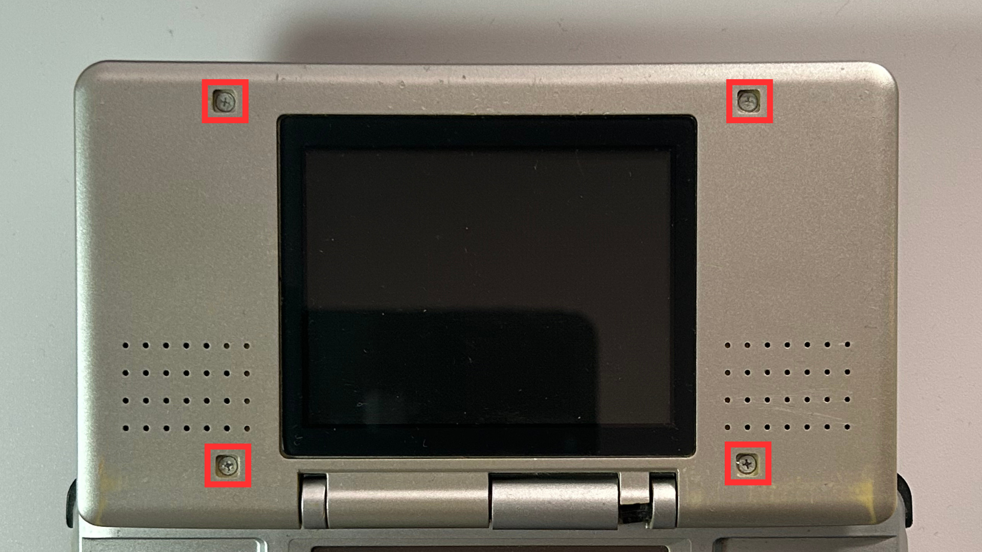 Phillips screws exposed around the top screen of an original Nintendo DS