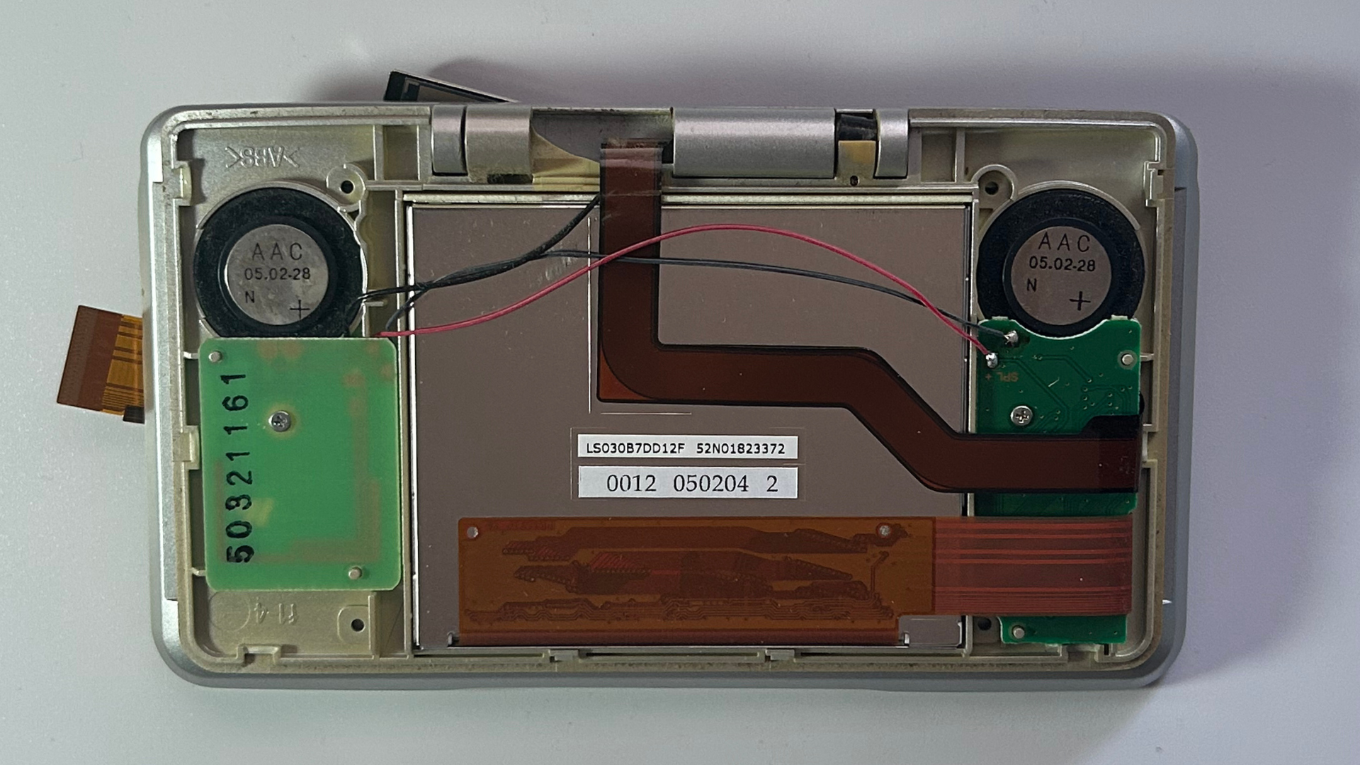 Original Nintendo DS upper screen housing opened to expose the internal components
