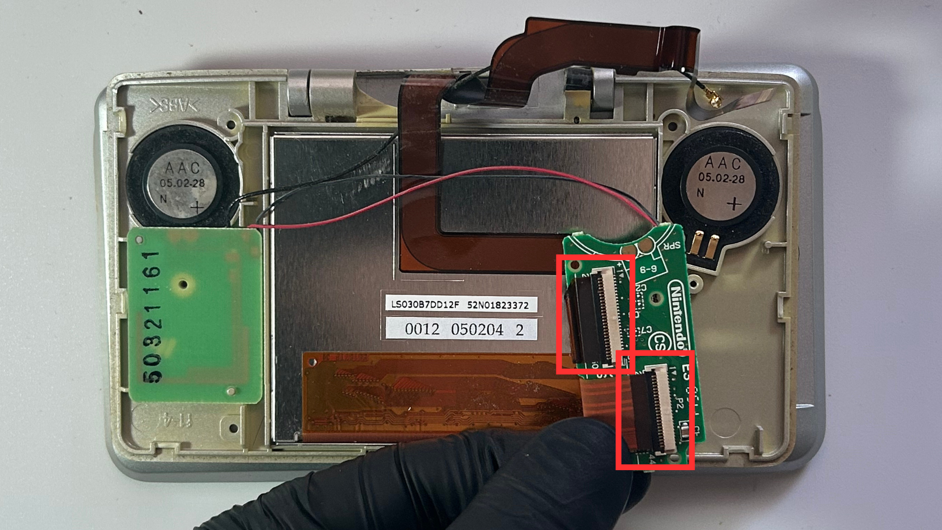 Ribbon cables being disconnected from the Nintendo DS speaker daughterboards
