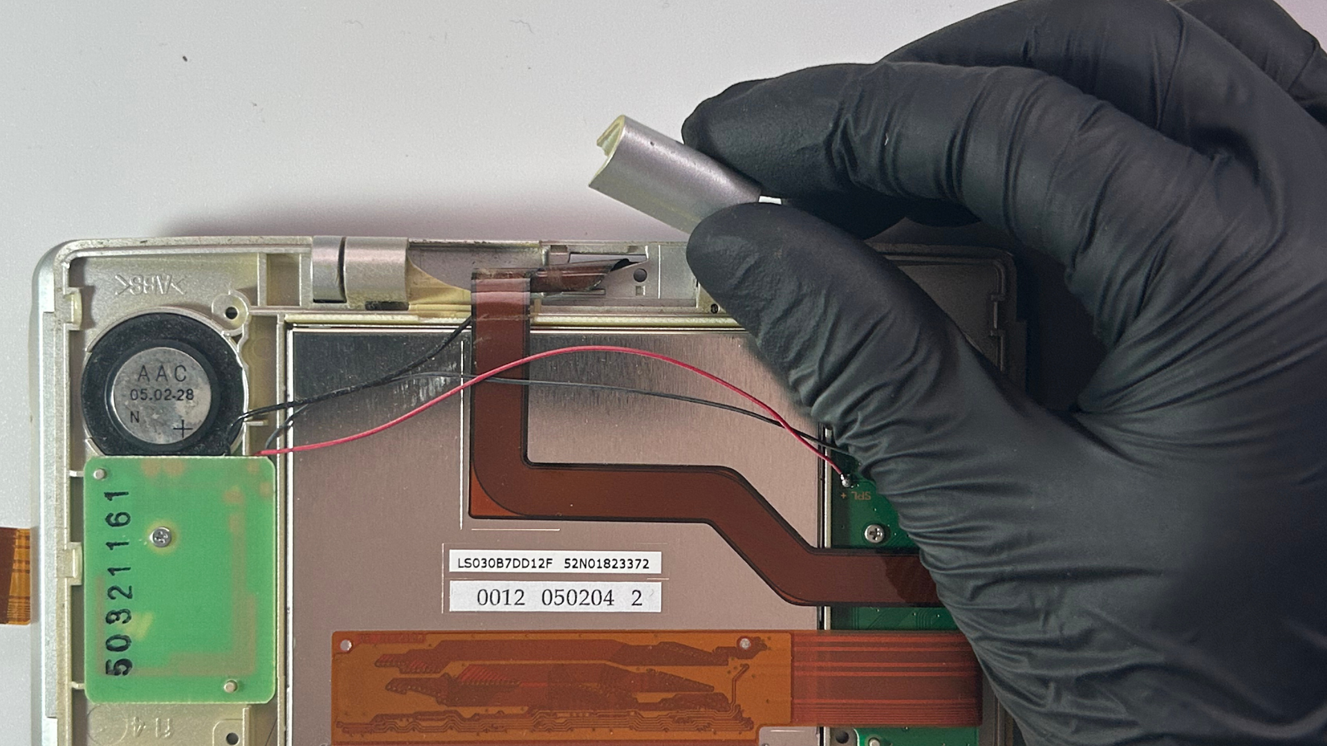 Nintendo DS yellow LCD spacer being removed