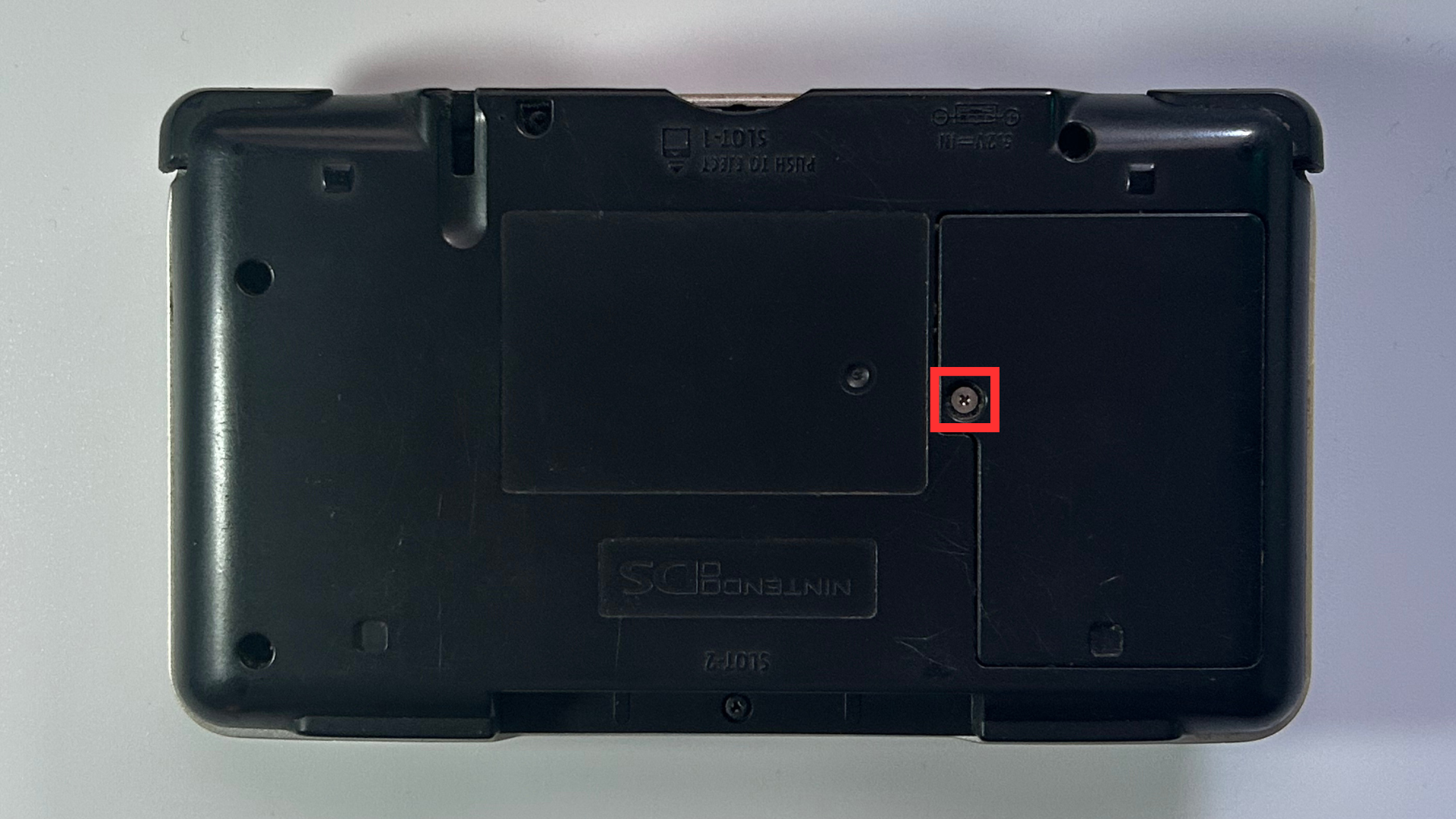 Original Nintendo DS showing the rear shell and screw locations