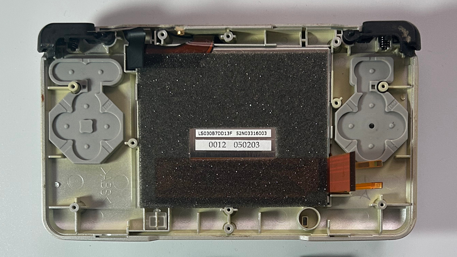 Nintendo DS ribbon cable connectors being disconnected from the motherboard