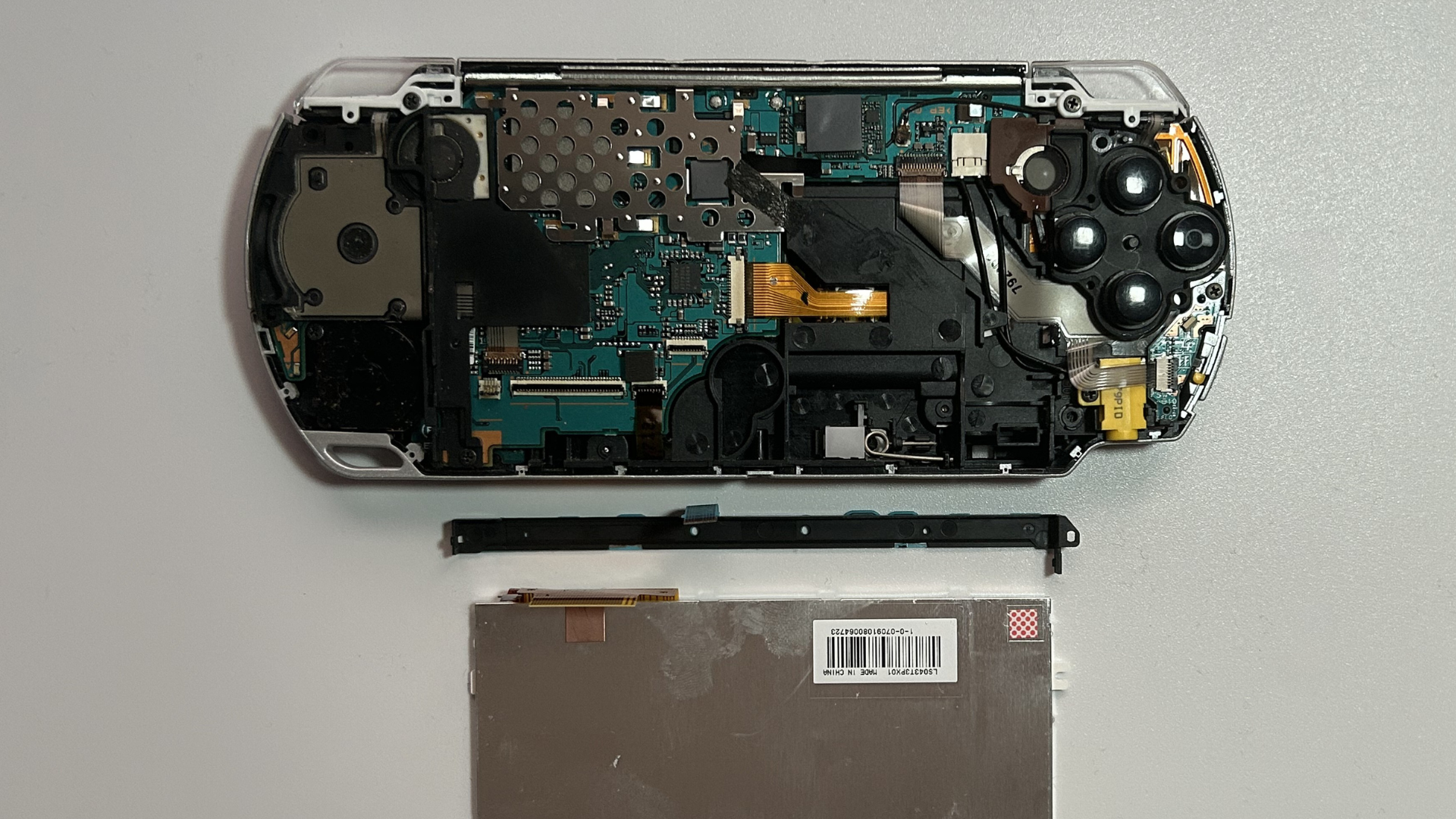PSP 2000 opened with LCD and control buttons flex detached